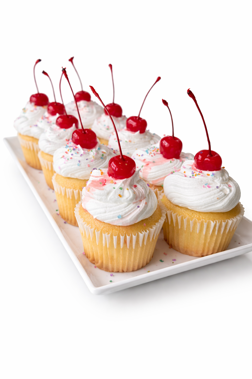 Vanilla cupcakes topped with cream and cherries